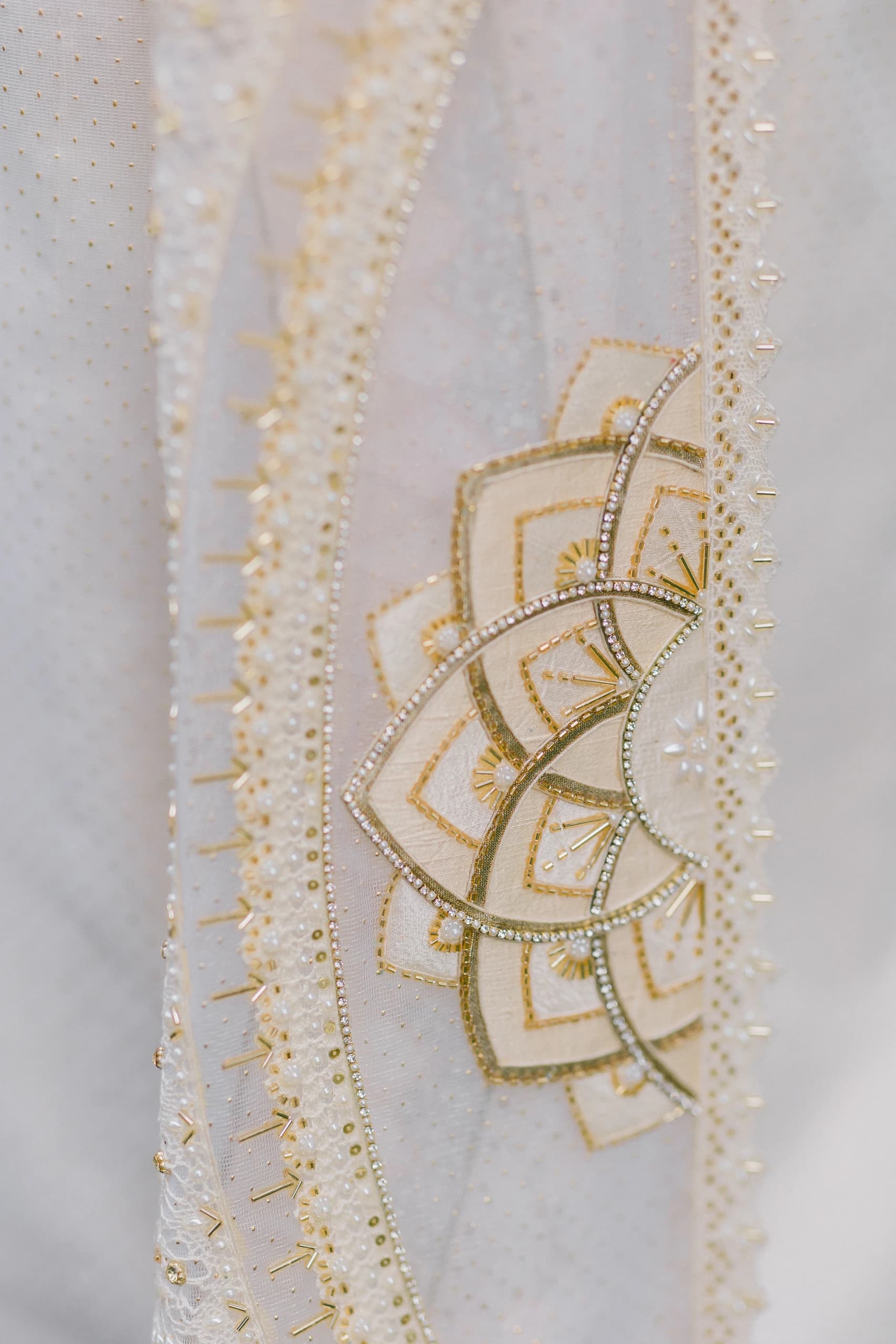Close view of gold embroidery on ivory bridal fabric